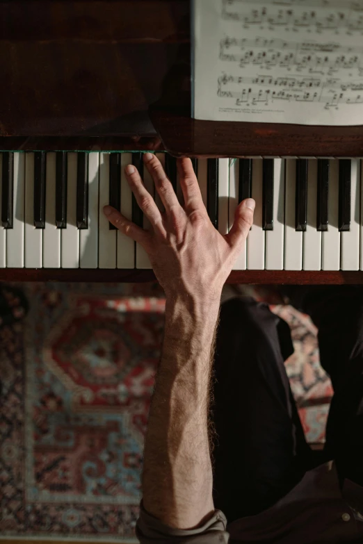 a close up of a person playing a piano, by Leo Michelson, laying down with wrists together, paul barson, sydney hanson, cinematic shot ar 9:16 -n 6 -g