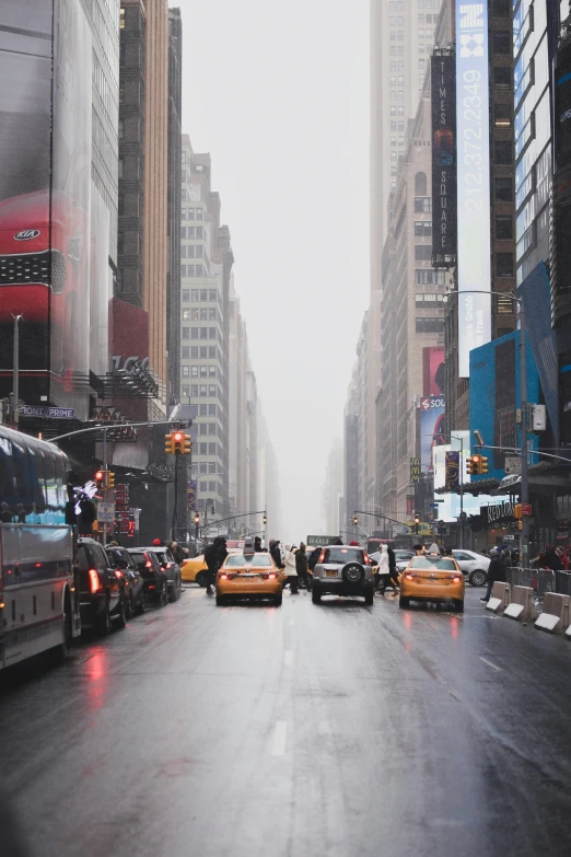 a city street filled with lots of traffic next to tall buildings, inspired by Thomas Struth, pexels contest winner, misty and raining, new york streets, taxis, gray sky