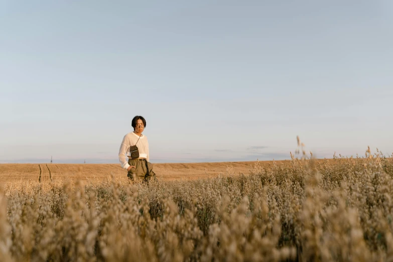 a man standing in a field of tall grass, an album cover, unsplash, happening, nishimiya shouko, in the steppe, avatar image, manuka