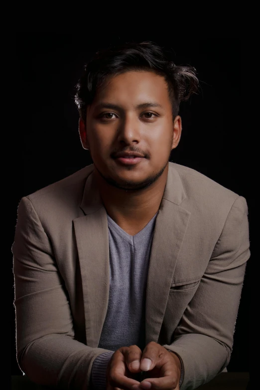 a man in a suit posing for a picture, an album cover, inspired by Byron Galvez, unsplash, hurufiyya, he is wearing a brown sweater, nepal, acting headshot, grayish