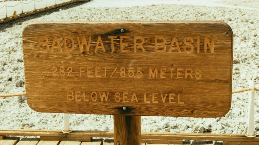 a wooden sign sitting on top of a sandy beach, by David Brewster, unsplash, dada, high elevation, ultra detailed water, base, very detailed labeling