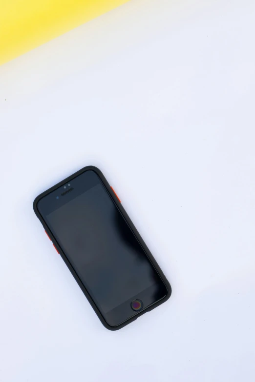 a cell phone sitting on top of a white table, trending on unsplash, red yellow black, low quality photo, shot on iphone 6, nice weather