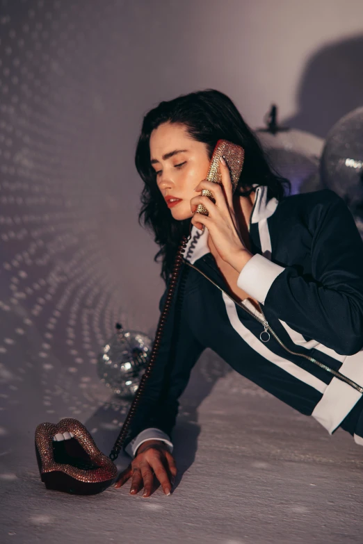 a woman laying on a bed talking on a phone, an album cover, by Elsa Bleda, trending on pexels, jennifer connelly, wearing disco suit, wearing a pinstripe suit, checking her phone