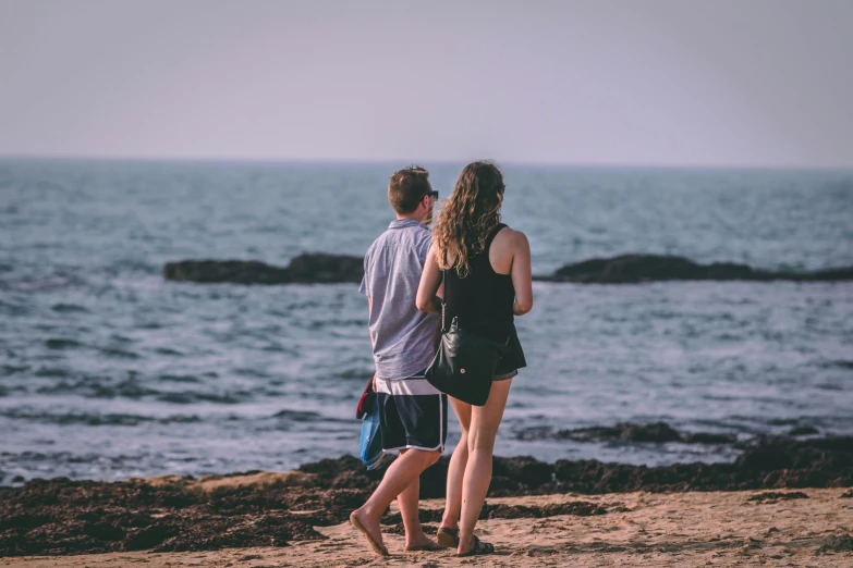 a man and a woman walking on a beach, pexels contest winner, teenage girl, looking out, instagram post, 1 2 9 7