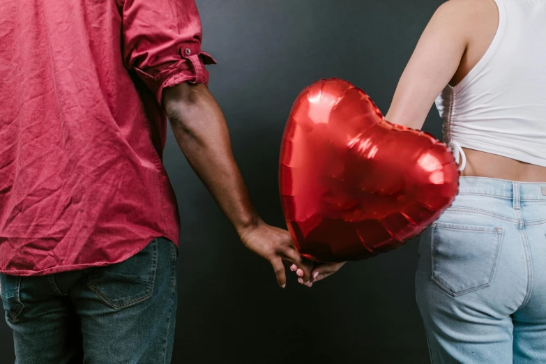 a man and a woman holding a heart shaped balloon, pexels contest winner, red and grey only, foil, brown, diverse