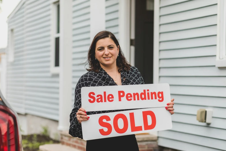 a woman holding a sold sign in front of a house, pexels contest winner, square, nekro petros afshar, profile image, extremely high resolution