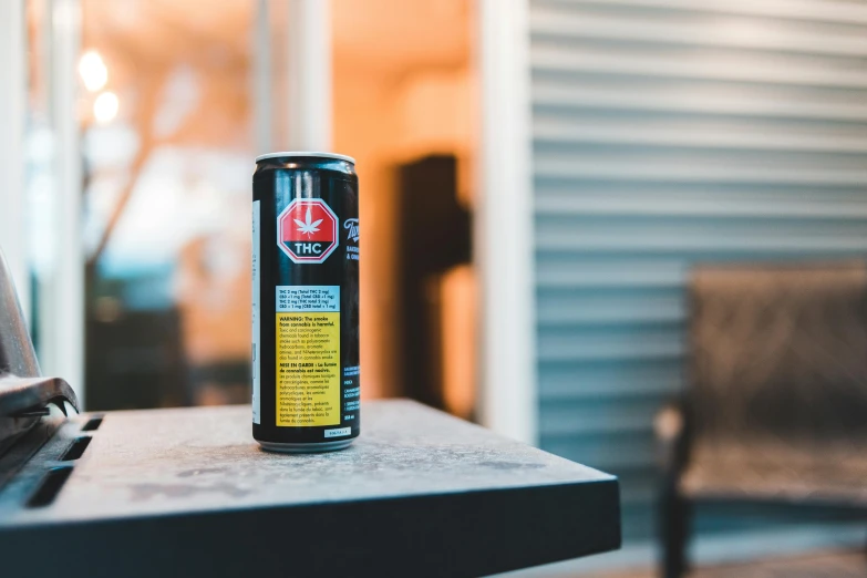 a can of soda sitting on top of a table, pexels contest winner, outside alone smoking weed, black and yellow and red scheme, toronto, energy drink