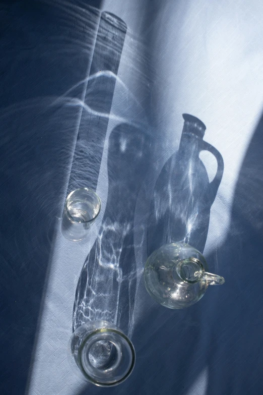 a couple of glass vases sitting on top of a table, a still life, inspired by Anna Füssli, renaissance, medical imaging, lit from below, close-up photograph, 2006 photograph