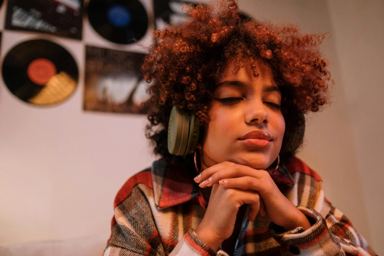 a woman sitting on a couch wearing headphones, trending on pexels, afrofuturism, brown curly hair, realistic », cottagecore hippie, earbuds jewelry