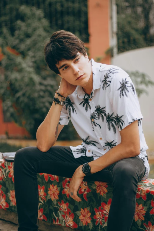 a young man sitting on top of a bench, inspired by John Luke, trending on pexels, elegant tropical prints, wears a watch, wearing shirts, avatar image