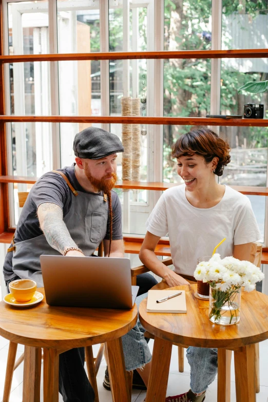 a man and woman sitting at a table with a laptop, by Jessie Algie, pexels contest winner, aussie baristas, millaise and greg rutkowski, planning, zachary corzine