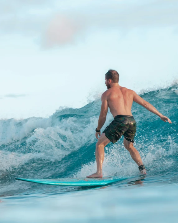 a man riding a wave on top of a surfboard, very buff, lgbtq, taken in 2 0 2 0, no cropping