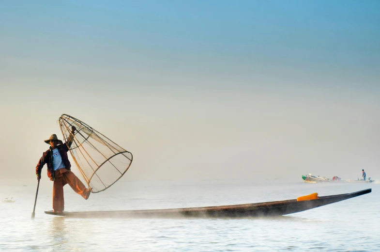 a man standing on top of a boat holding a net, inspired by Steve McCurry, pexels contest winner, hurufiyya, panoramic shot, myanmar, 15081959 21121991 01012000 4k, traditional dress