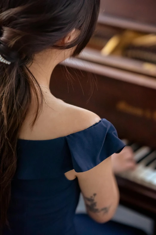 a woman in a blue dress playing a piano, inspired by Zheng Xie, trending on pexels, arabesque, neck zoomed in, hands behind back, vietnamese woman, girl with brown hair