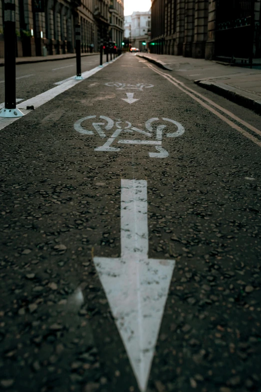 a white arrow painted on the side of a road, by Matt Stewart, unsplash, bicycles, 15081959 21121991 01012000 4k