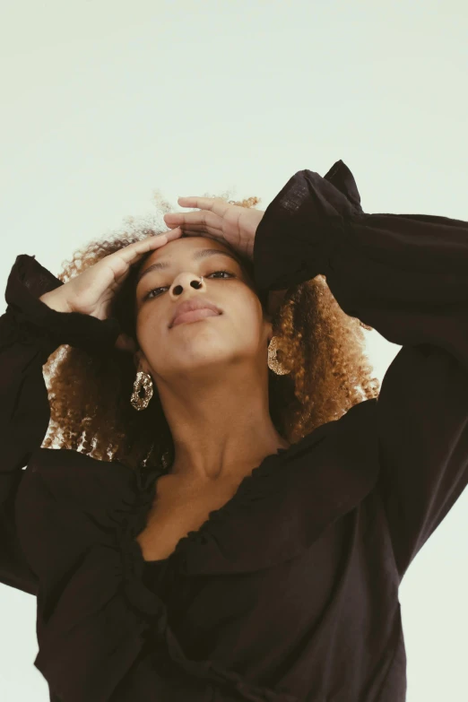 a woman standing with her hands on her head, trending on pexels, renaissance, casual black clothing, curls on top, ashteroth, light from bottom