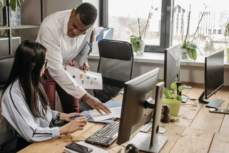 a couple of people that are sitting in front of a computer, trending on pexels, standing on a desk, varying ethnicities, engineer, teaching