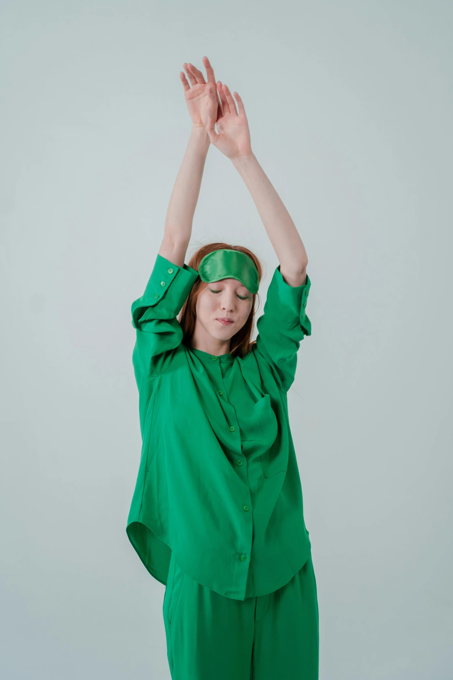 a woman in a green outfit doing a yoga pose, an album cover, by Anna Füssli, trending on pexels, renaissance, blindfold, default pose neutral expression, androgynous person, raised hand