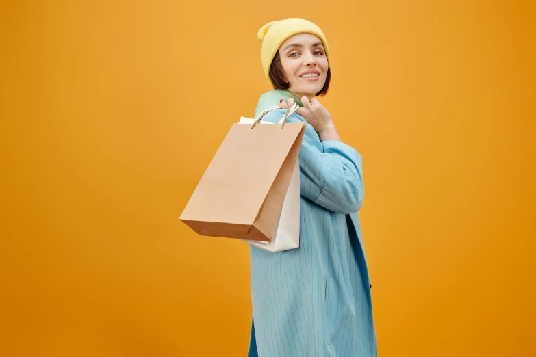 a woman in a yellow hat is holding shopping bags, trending on pexels, figuration libre, wearing a simple robe, avatar image, skincare, wearing a blue hoodie