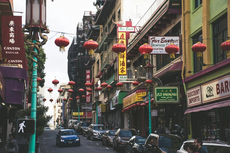 a street filled with lots of traffic next to tall buildings, chinese lanterns, san francisco, black and yellow and red scheme, green alleys