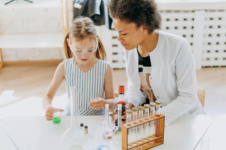 a woman and a little girl sitting at a table, chemistry, gen z, reagents, from waist up