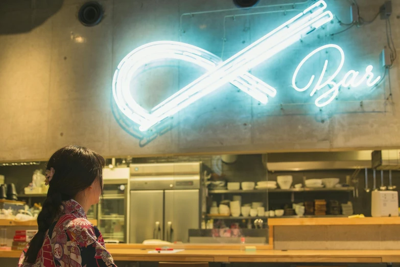 a woman sitting at a table in front of a neon sign, pexels contest winner, infinity symbol, ( waitress ) girl, studio kyoto, in a kitchen