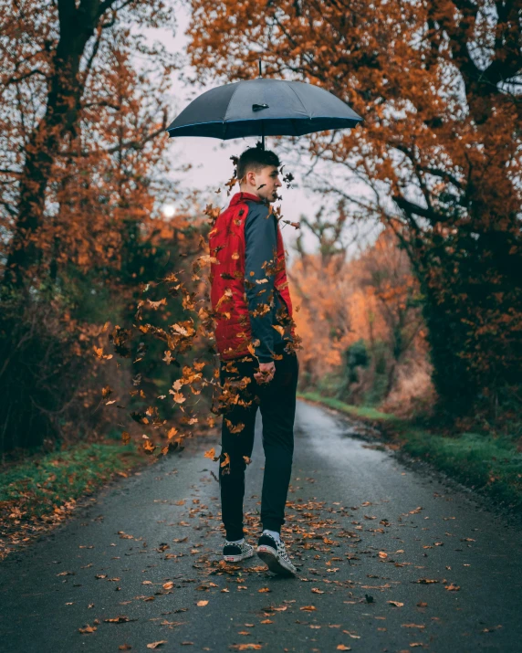 a man standing in the middle of a road holding an umbrella, falling leaves, profile image, thumbnail, attractive photo