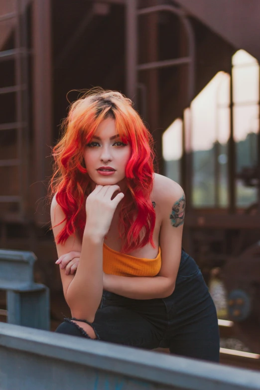 a woman with red hair posing for a picture, inspired by Elsa Bleda, trending on pexels, industrial colours, better known as amouranth, sunset lighting, cool tousled hair