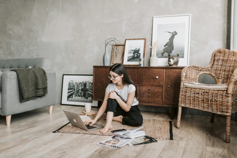 a woman sitting on the floor using a laptop, a picture, by Emma Andijewska, pexels contest winner, furniture around, 1 2 9 7, professional artwork, an elegant