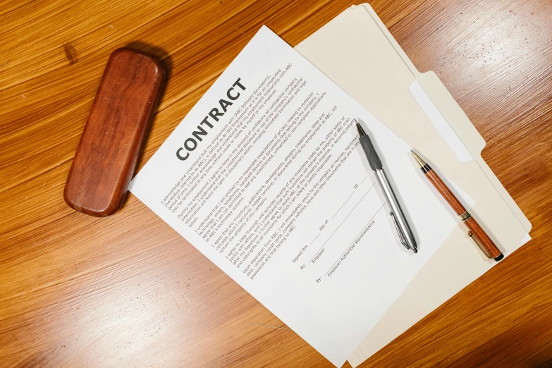 a piece of paper sitting on top of a wooden table, by Daniel Lieske, pexels contest winner, high contract, contracting colors mood, fine pen, commercial