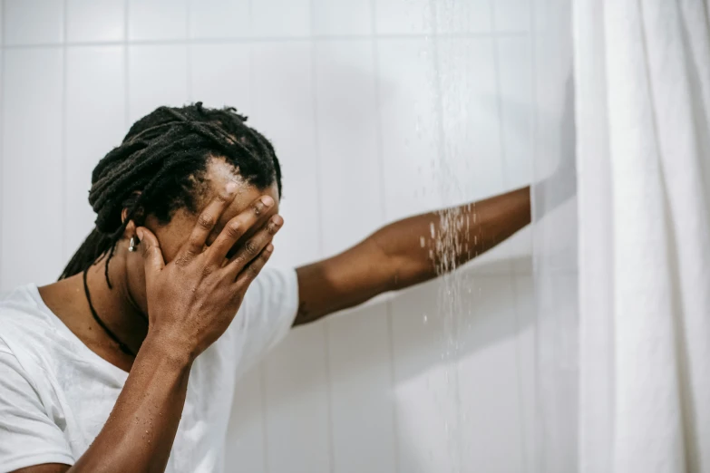 a man standing in front of a shower holding his hands to his face, trending on pexels, renaissance, photo of a black woman, in distress, pouring, faceless people