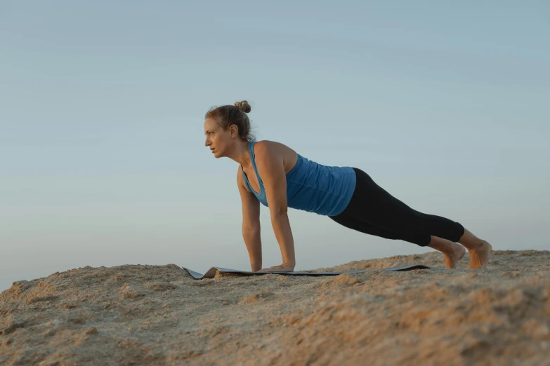 a woman doing a yoga pose on a beach, by Jessie Algie, 4k photo”, “ iron bark, laying down, manuka