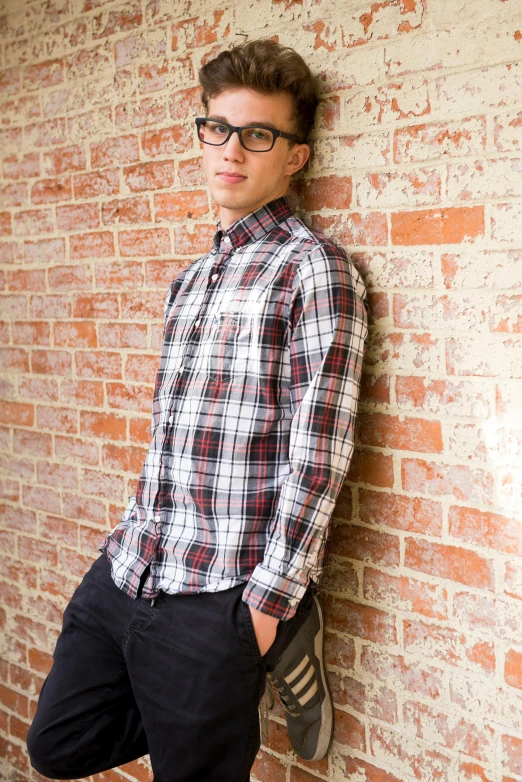 a young man leaning against a brick wall, plaid shirt, official store photo, john egbert, jc park