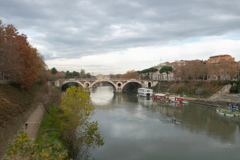 a group of boats floating on top of a river, by Cagnaccio di San Pietro, pexels contest winner, neoclassicism, stone bridge, panoramic, slight overcast, 2 0 0 0's photo