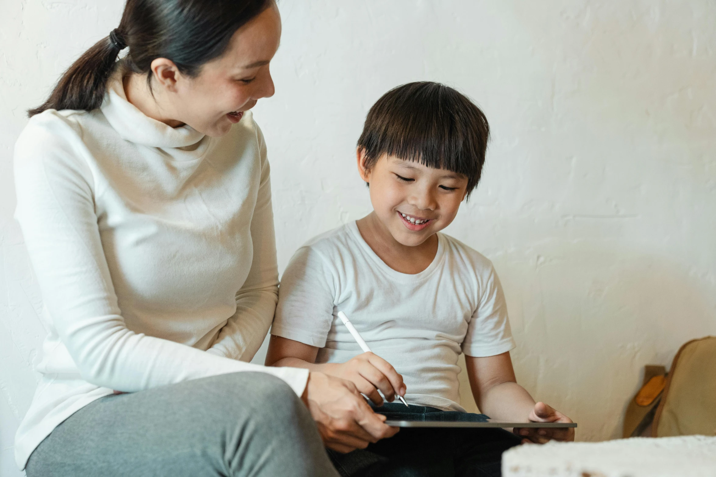 a woman sitting next to a child on a bed, a child's drawing, pexels contest winner, mingei, holding a clipboard, casual game, te pae, full device