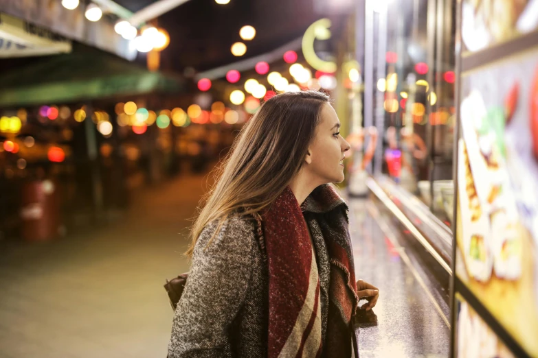 a woman standing in front of a window at night, pexels contest winner, happening, people shopping, australian winter night, left profile, warm street lights store front