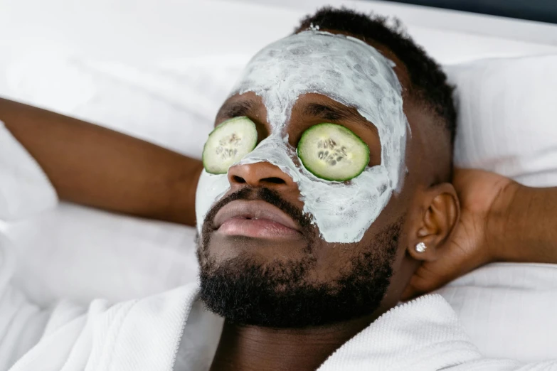 a man laying in bed with cucumbers on his eyes, trending on pexels, renaissance, black mask, with grey skin, candy treatments, robe. perfect faces