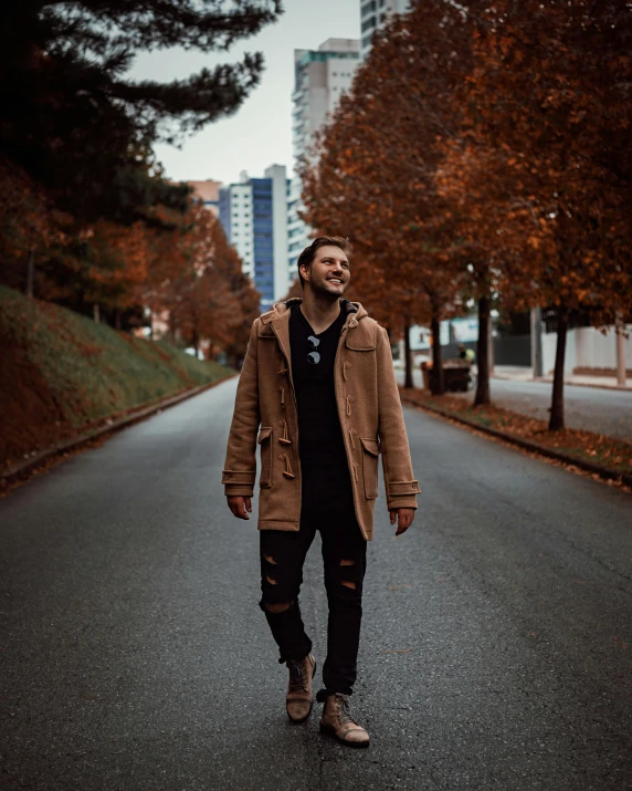 a man standing in the middle of a road, an album cover, pexels contest winner, 🍂 cute, vancouver, lgbtq, brown clothes