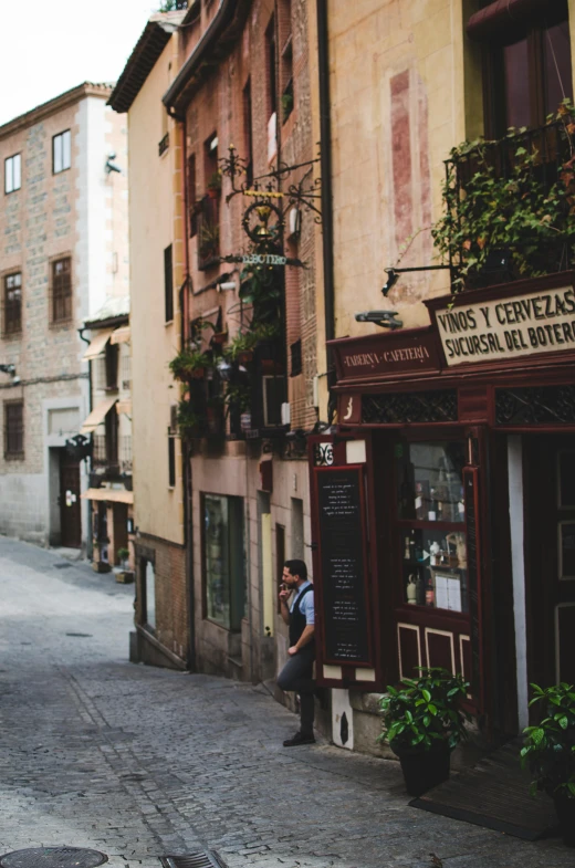 a couple of people that are walking down a street, inspired by Modest Urgell, pexels contest winner, local bar, built on a steep hill, young spanish man, eating