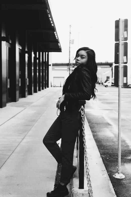 a black and white photo of a woman leaning against a pole, sza, dressed in leather jacket, tessa thompson inspired, blackpink jennie