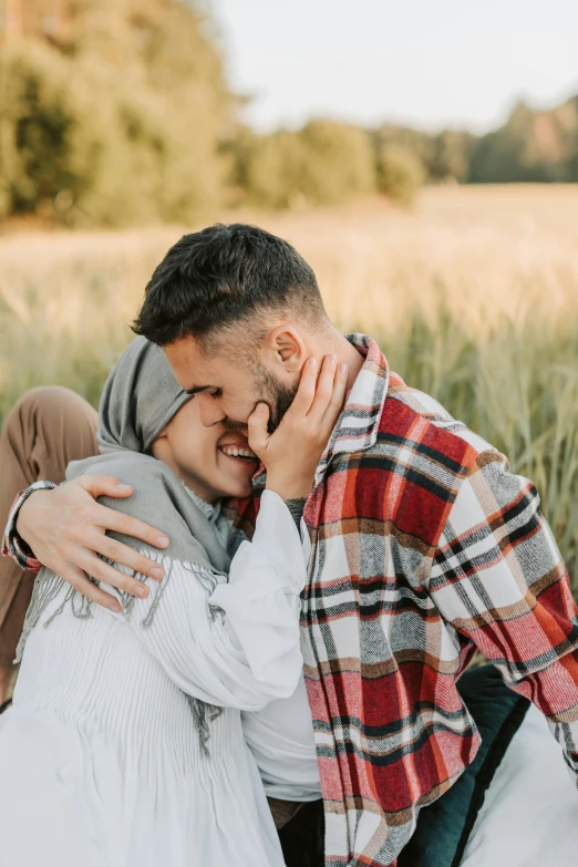 a man and woman sitting on a blanket in a field, pexels contest winner, hurufiyya, kissing smile, muslim, man grabbing a womans waist, teenage boy