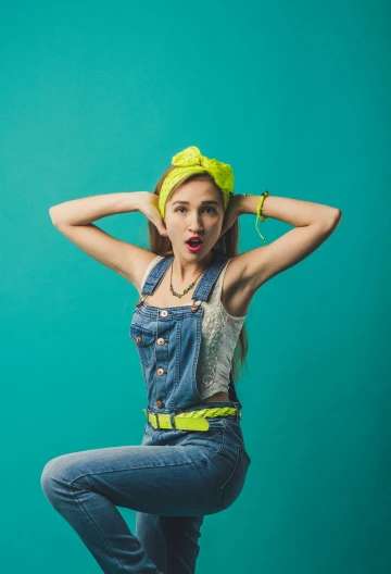 a woman in overalls posing with her hands on her head, trending on pexels, pop art, teal headband, wearing hi vis clothing, vintage clothing, youthful colours