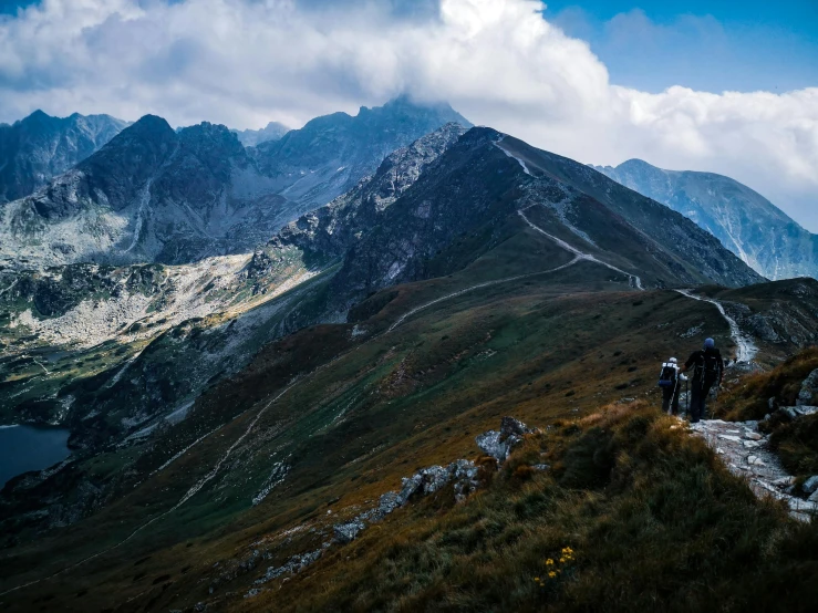 two people hiking up the side of a mountain, by Emma Andijewska, pexels contest winner, mountains in distance, avatar image, poland, thumbnail