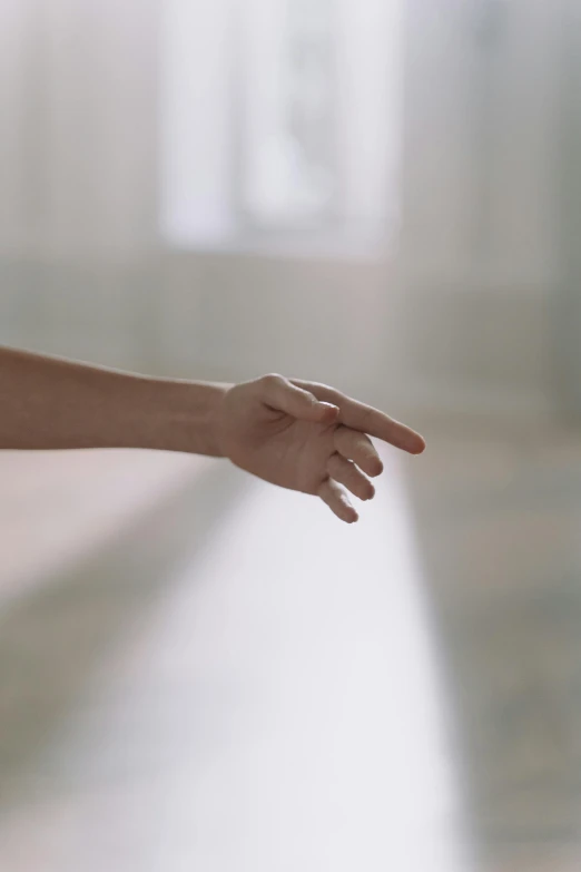 a close up of a person holding a frisbee, by Elsa Bleda, hyperrealism, reaching out to each other, in the middle of an empty room, pointing index finger, ultra realistic. cinematic