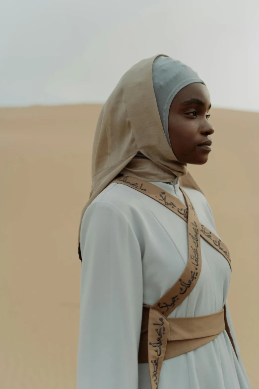 a woman standing in the middle of a desert, afrofuturism, white hijab, from netflix's arcane, photo of young woman, ( ( theatrical ) )