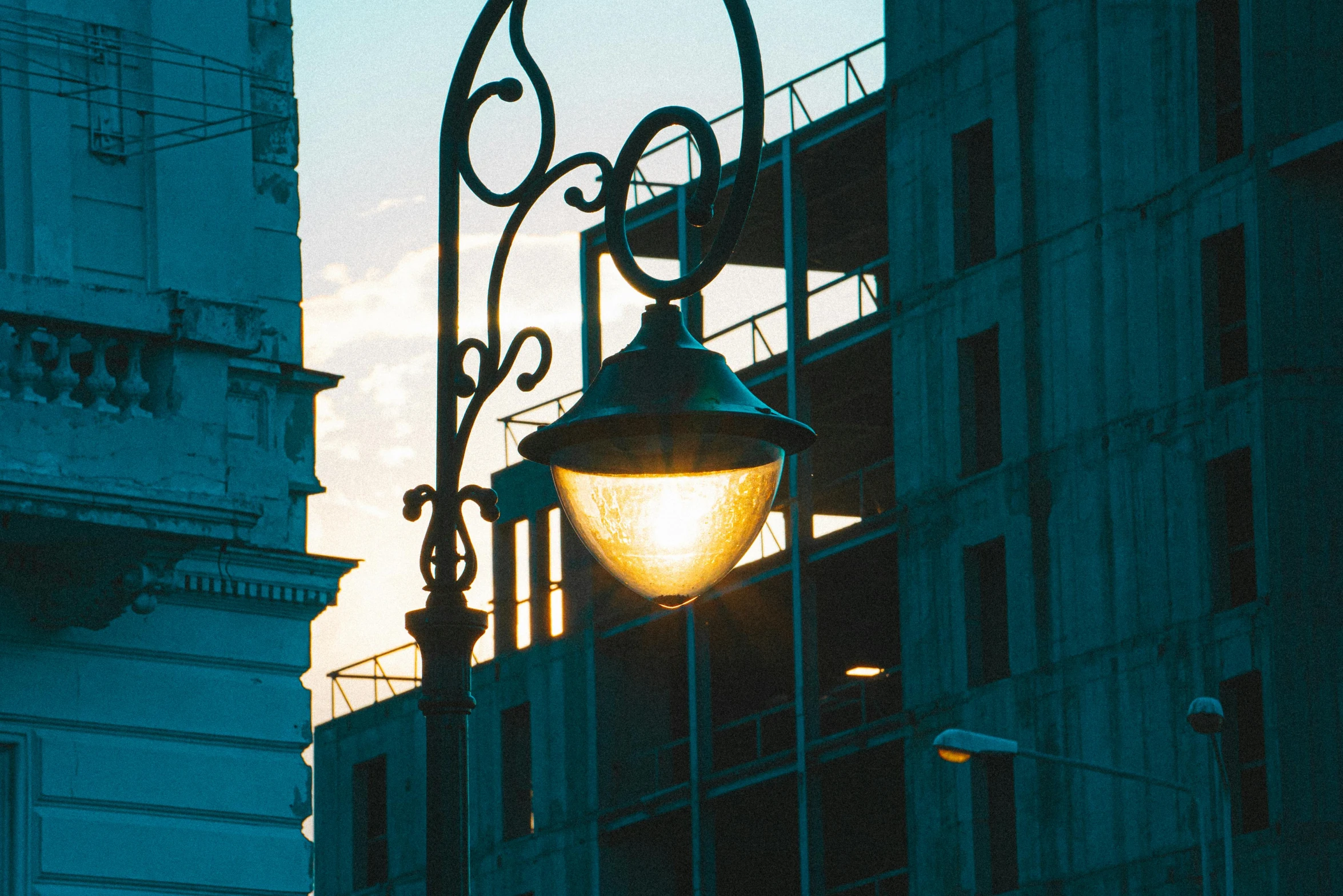 a street light with a building in the background, inspired by Carl Spitzweg, unsplash contest winner, art nouveau, verdigris, evening sunlight, construction, taken in 1 9 9 7