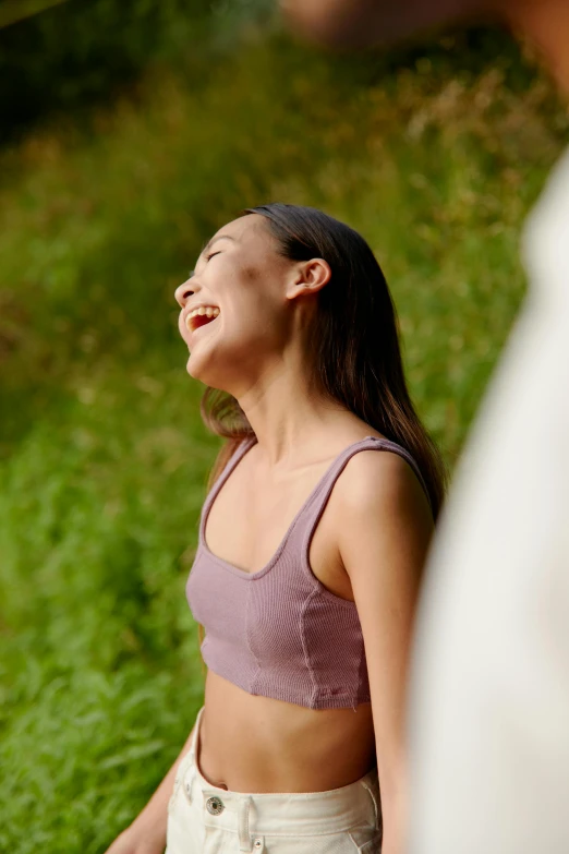 a woman standing next to a man holding a frisbee, inspired by Kim Tschang Yeul, trending on pexels, happening, wearing purple undershirt, head bent back in laughter, wearing a crop top, nature outside