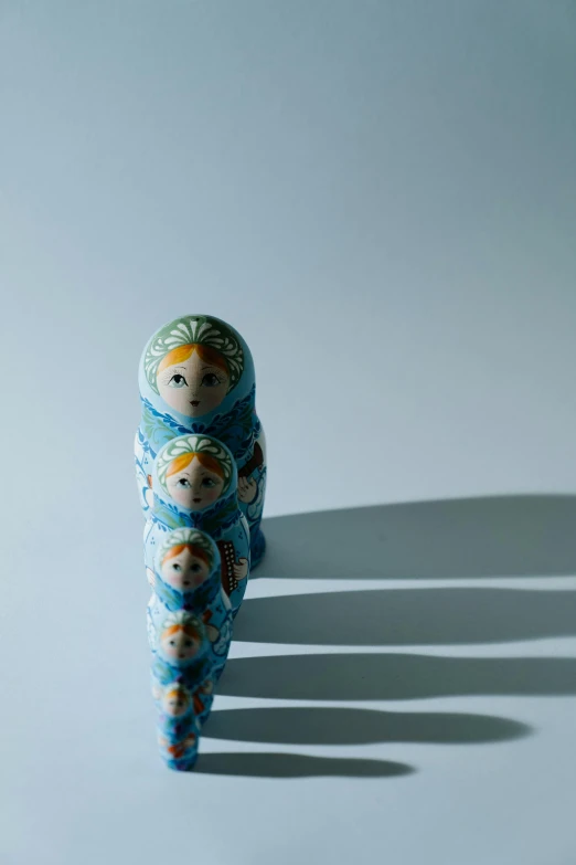 a group of dolls sitting on top of a white surface, by Jesper Knudsen, unsplash, cloisonnism, dipped in polished blue ceramic, russia, stacked image, directional sunlight skewed shot