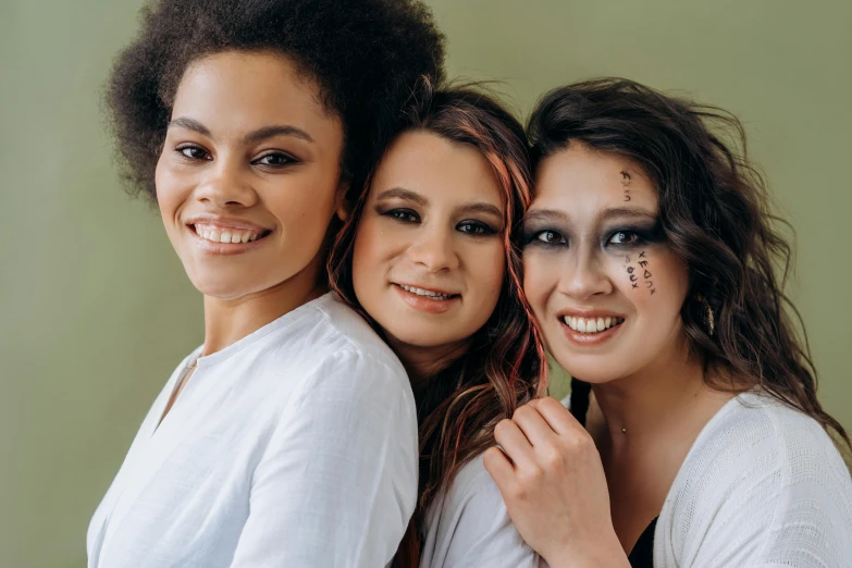 a group of three women standing next to each other, trending on pexels, antipodeans, stylized make-up on face, mixed race, brown, portrait n - 9