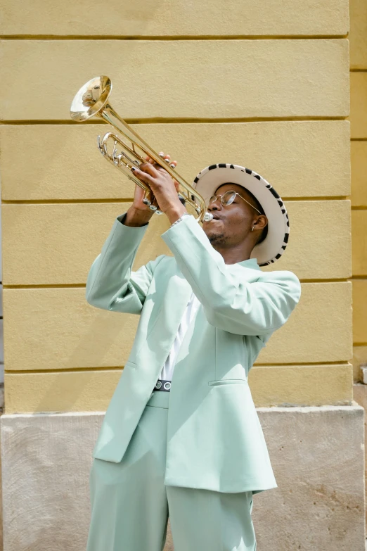 a man in a blue suit playing a trumpet, pexels contest winner, harlem renaissance, sea - green and white clothes, high hat, summer weather, in a gold suit